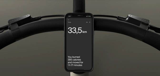 Front view of the app attached to a bike's handlebar, showing calories burned and ridden distance on the screen.